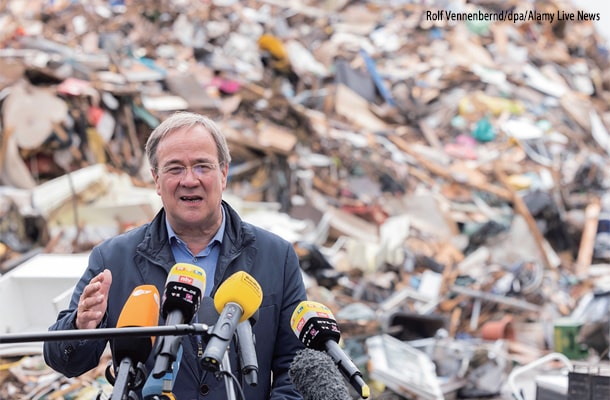 2日、ドイツ西部で起きた洪水によるゴミの山の前で話すラシェット州首相