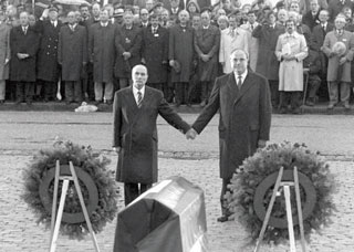 戦没者墓地の納骨堂の前で手を握り合うミッテラン仏大統領（左）とコール西独首相