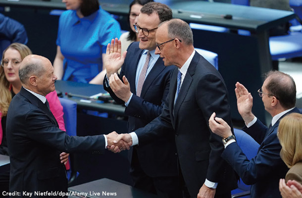 5月6日、ショルツ前首相と握手するメルツ首相
